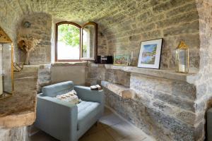 a living room with a couch and a stone wall at Two-Villa Estate with Pool & Valley Views in Salvagnac-Cajarc