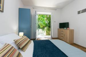 a bedroom with a bed and a tv on a dresser at Apartmani Drašnice 2 in Drašnice