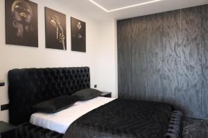 a bedroom with a bed with a black headboard at Prestige Apartments in Shkodër