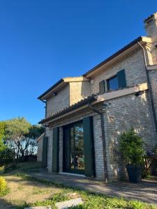 una casa de ladrillo con una ventana lateral en Casa Valentina, en Novilara