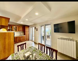 eine Küche mit einem Esstisch und einem TV in der Unterkunft SAN - Luxury Apartment in Santa Maria di Castellabate