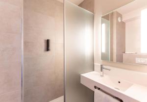 Un baño con ducha, lavabo y espejo. en B&B HOTEL Cholet Nord, en Cholet 22 fotos más