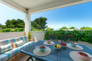 a blue table with bowls of fruit on a patio at Apartmani Drašnice 2 in Drašnice