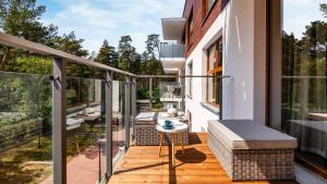 ein Balkon eines Hauses mit einem Tisch und Stühlen in der Unterkunft Stegna Park II blisko morza Apartamenty Piamola in Stegna