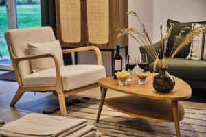 a living room with a chair and a table with wine glasses at Hospedería Quinta de Cavia in Cabia