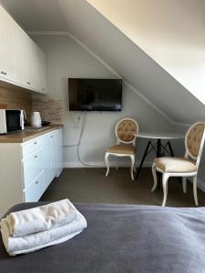 a room with two chairs and a table and a tv at Apartamenty Giżycko in Giżycko