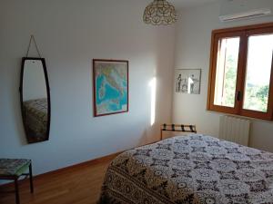 a bedroom with a bed and a mirror on the wall at Carachouse Pellaro in Pellaro
