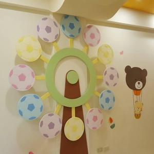 Una habitación infantil con una pared con un oso y pelotas. en Happy to Meet Bed and Breakfast, en Taitung