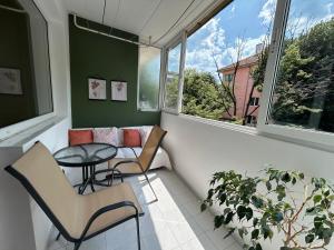 a balcony with a table and chairs and a window at Nana's apartment in Varna City