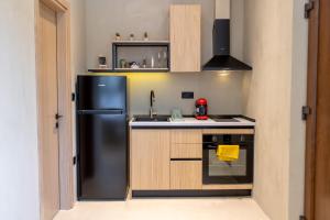 a kitchen with a black refrigerator and a stove at Cactus in Asprovalta