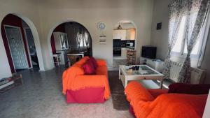 a living room with two orange chairs and a table at Casa Tanja in Teulada