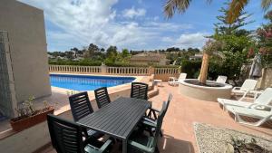a patio with a table and chairs and a pool at Casa Tanja in Teulada