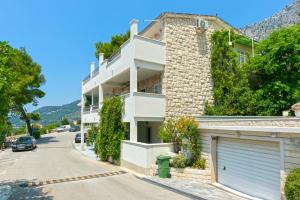 a building on a street with a garage at Apartmani Drašnice 2 in Drašnice
