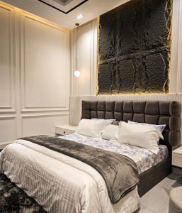 a bedroom with a large bed with a stone wall at The White Suites in Karachi +167 photos