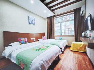 una camera d'albergo con due letti e una finestra di A deer has you INN near by Tianmen Shan a Zhangjiajie