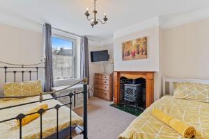 a bedroom with two beds and a fireplace at 4 bedroom house near Burton Latimer, Wellingborough and Isham in Isham +7 photos