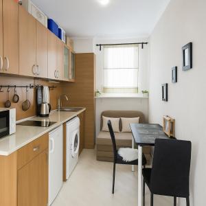 a small kitchen with a table and a dining room at Helios Seaview Apartment in Sveti Vlas