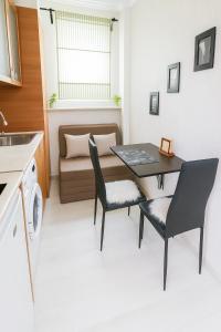 a kitchen with a table and chairs and a couch at Helios Seaview Apartment in Sveti Vlas