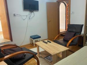 a living room with a tv and a table and chairs at Apartman Roko in Tribunj