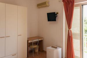 a small room with a desk and a tv on the wall at Vbeb Macrame Rooms Agrigento in Villaggio Mosè +34 photos
