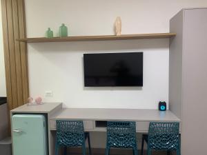 a kitchen with a table with chairs and a tv at Amarílis Riviera-Estúdio A-209 in Bertioga