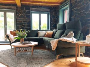 a living room with a green couch and a table at Ferienhaus NaturReich in Bad Berleburg