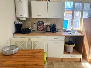 a kitchen with white cabinets and a counter top at Apartman Roko in Tribunj +10 photos