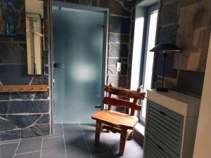 a wooden chair sitting in front of a door at Ferienhaus NaturReich in Bad Berleburg +29 photos