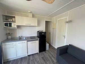 a small kitchen with a sink and a refrigerator at Camping Le Parc des Chênes in La Croix-Valmer