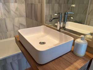 Un lavabo blanco en un baño junto a una bañera. en Marina Playa, en La Herradura