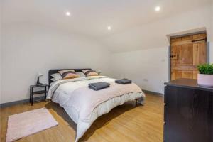 a bedroom with a large bed and a dresser at Zest Homes 87 Bridge Street in Leominster
