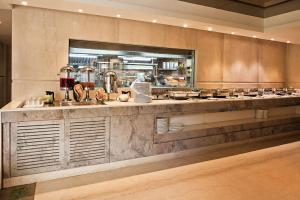 a restaurant kitchen with a counter with food on it at Barsana Boutique Hotel - Pure vegetarian in Kolkata