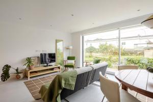 a living room with a table and chairs and a television at Algae n'areia in Moledo