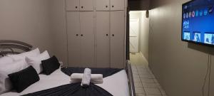 a bedroom with a bed and a tv in it at NEW LODGE - Willows in Bloemfontein +1 photo