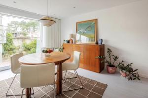 a dining room with a wooden table and chairs at Algae n'areia in Moledo