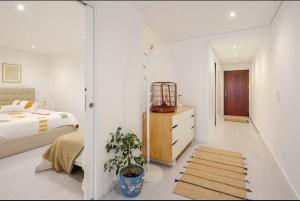 a white bedroom with a bed and a mirror at Algae n'areia in Moledo