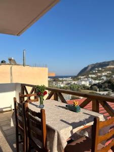 a table with a vase of flowers on a balcony at Serenity in Kefalos