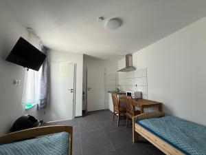 a room with a bed and a table and a kitchen at Neu 2025 Apartment mit Bad und Küche zwischen Köln und Bonn in Wesseling