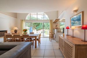 a living room with a table and a dining room at Résidence Lagrange Vacances Villas Atlantic Green in Lacanau-Océan