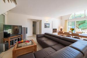 a living room with a couch and a flat screen tv at Résidence Lagrange Vacances Villas Atlantic Green in Lacanau-Océan