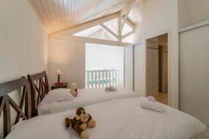a bedroom with three beds with teddy bears on them at Résidence Lagrange Vacances Villas Atlantic Green in Lacanau-Océan +34 photos