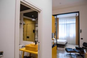 un bagno con un lavandino giallo e una stanza di Palazzo Sebeto a Napoli Altre 209 foto