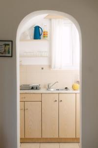 an archway leading into a kitchen with a sink at Perama Studios in Agios Prokopios