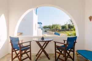 a table and chairs in a room with a window at Perama Studios in Agios Prokopios