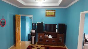 a living room with a blue wall and a tv at Darajat Homestay in Darajat