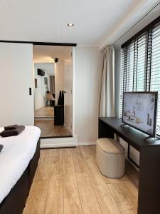 a bedroom with a bed and a desk and a mirror at Vakantiehuisje Noé in Gorinchem