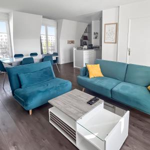 ein Wohnzimmer mit einem blauen Sofa und einem Tisch in der Unterkunft Appartement lumineux avec terrasse et parking in Chessy