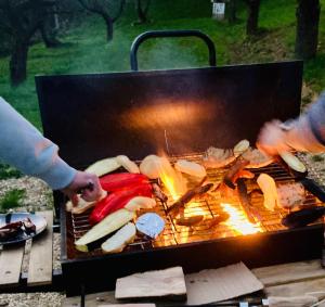 a group of people cooking food on a grill at Camping centra Shambhala in Lúčka