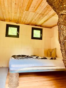 a mattress bed in a room with two windows at Camping centra Shambhala in Lúčka