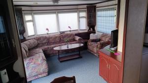 a living room with a couch and a tv at U Jacka za łąką in Zabiele